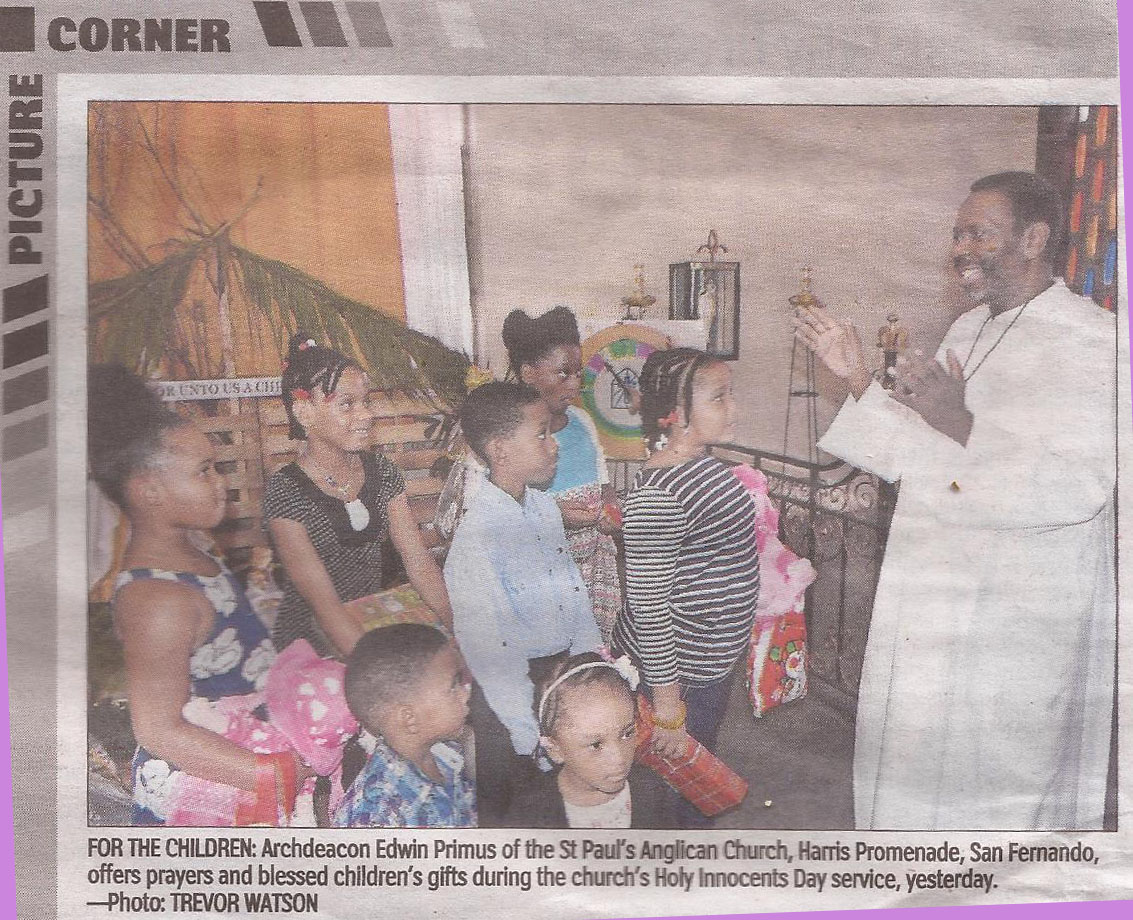 For The Children: Archdeacon Edwin Primus of the St. Paul's Anglican Church, Harris Promenade, San Fernando, offers prayers and blessed children's gifts during the church's Holy Innocents Day service, yesterday. -- Photo: Trevor Watson